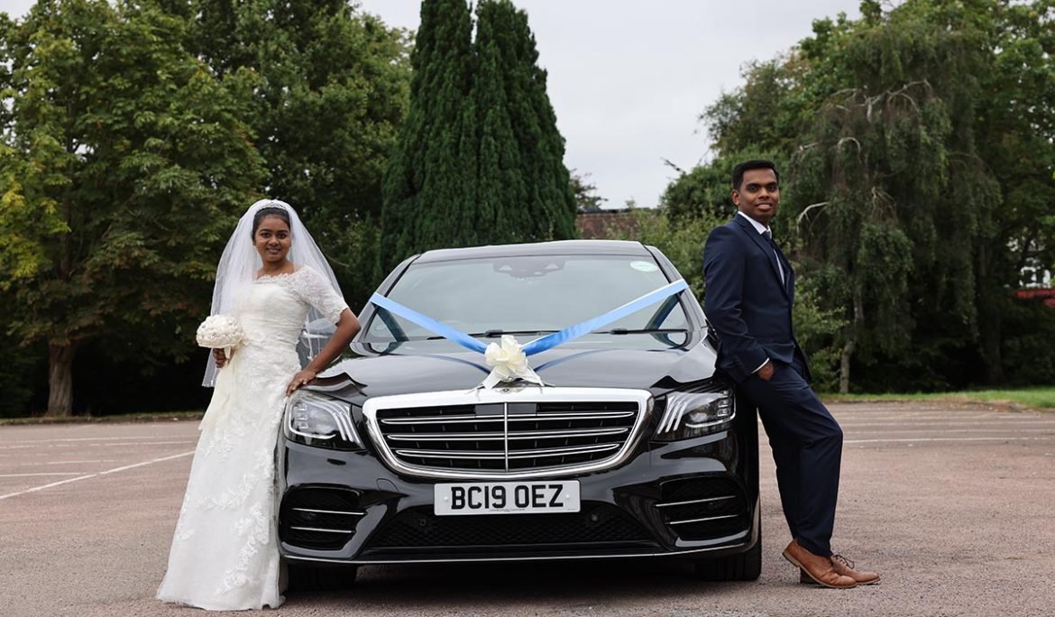 Bride and groom posing beside their wedding car captured by a Christian Wedding Photographer in London