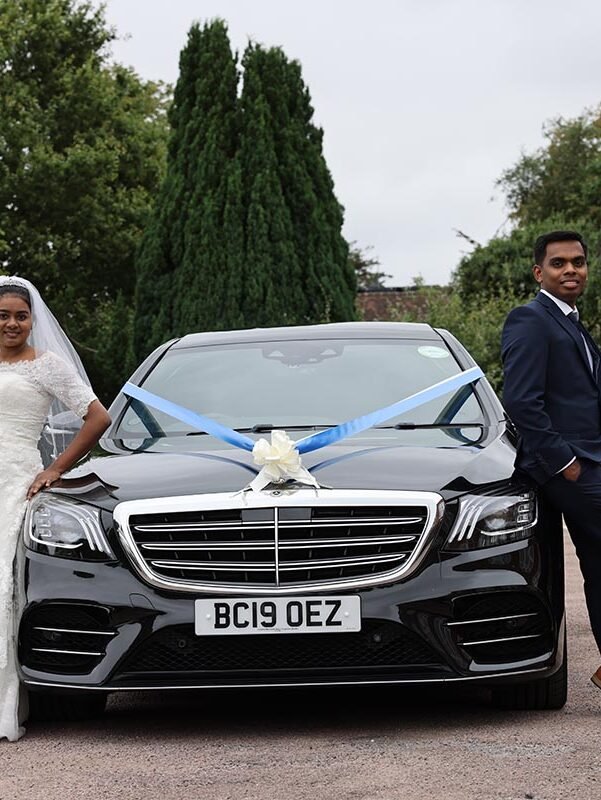 Bride and groom posing beside their wedding car captured by a Christian Wedding Photographer in London